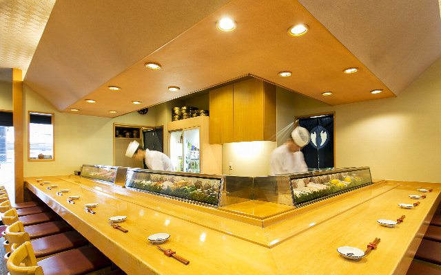 カウンターで寿司を握っている男性の画像